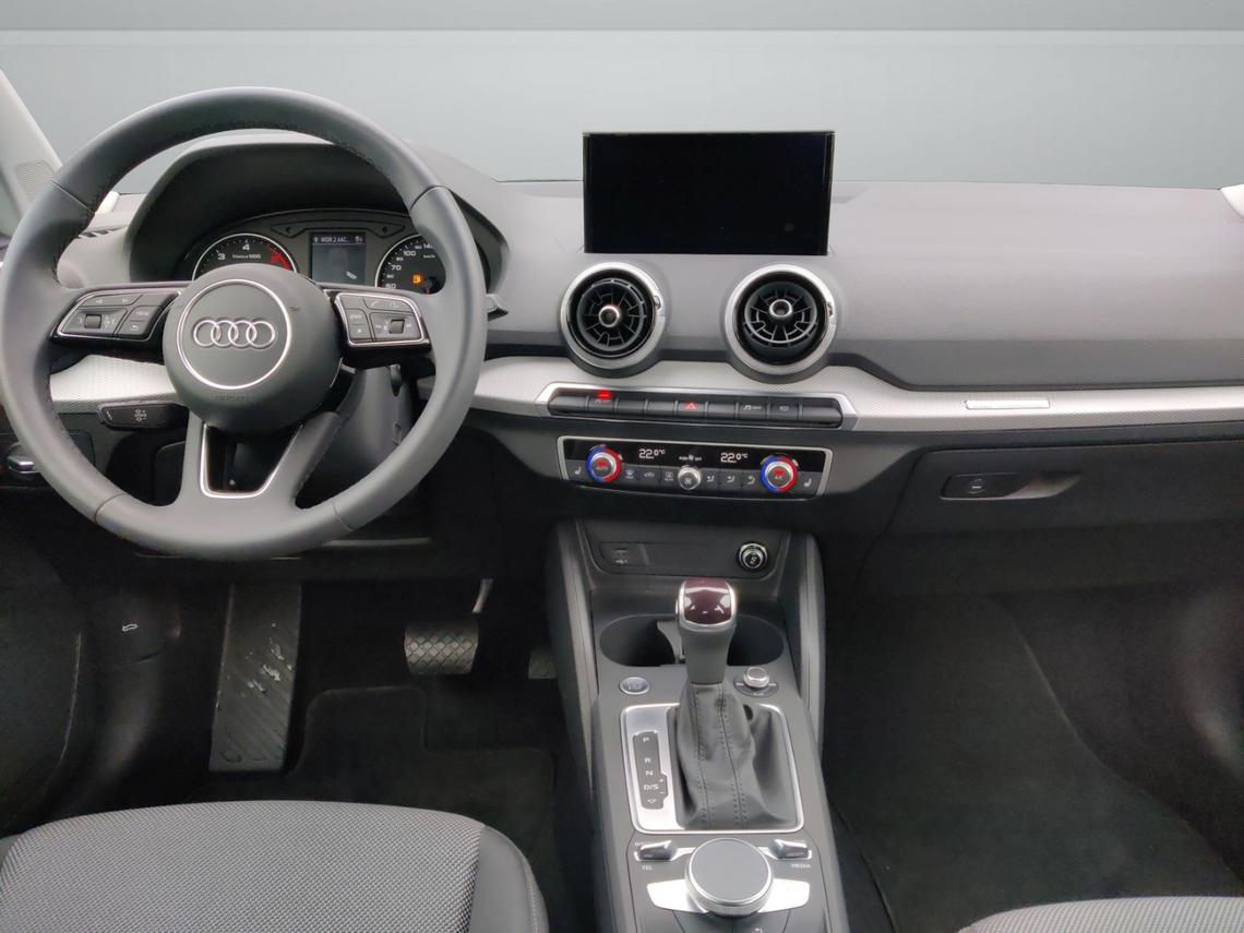 Innenansicht eines roten Audi Q2. Blick auf Armaturenbrett und Mittelkonsole.