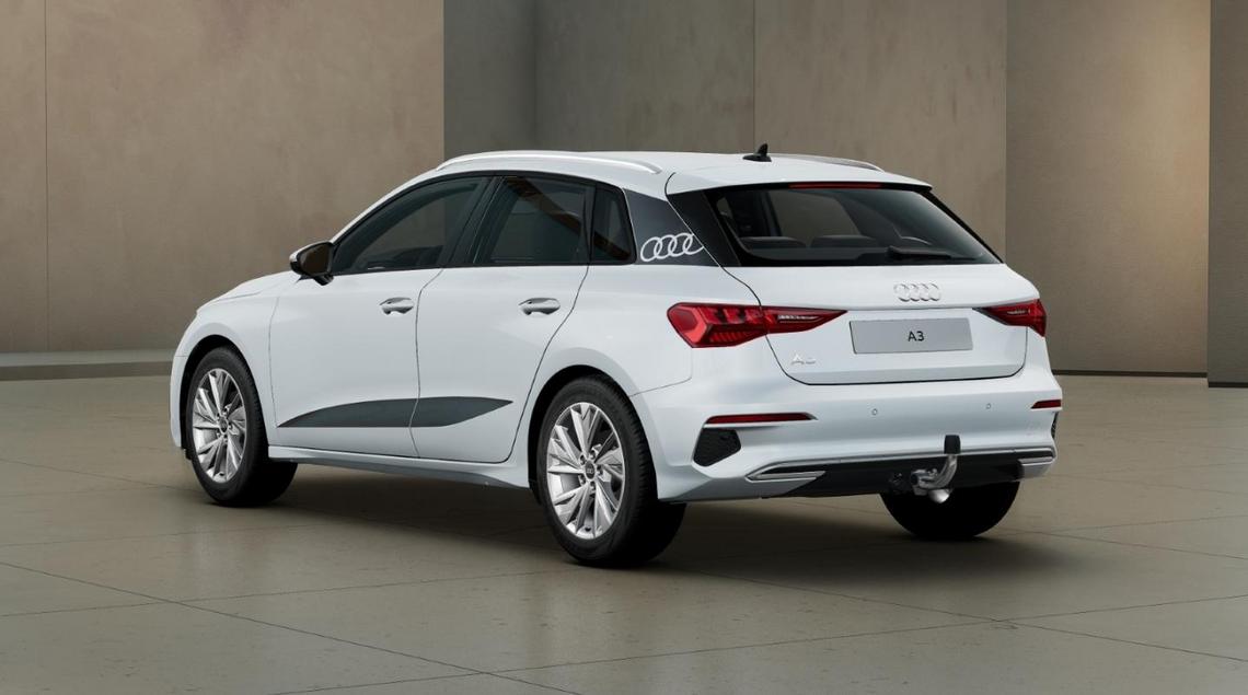 Heck-Links Ansicht eines weißen Audi A3 Sportback vor neutralem beigen Hintergrund. Technisch generiertes Bild