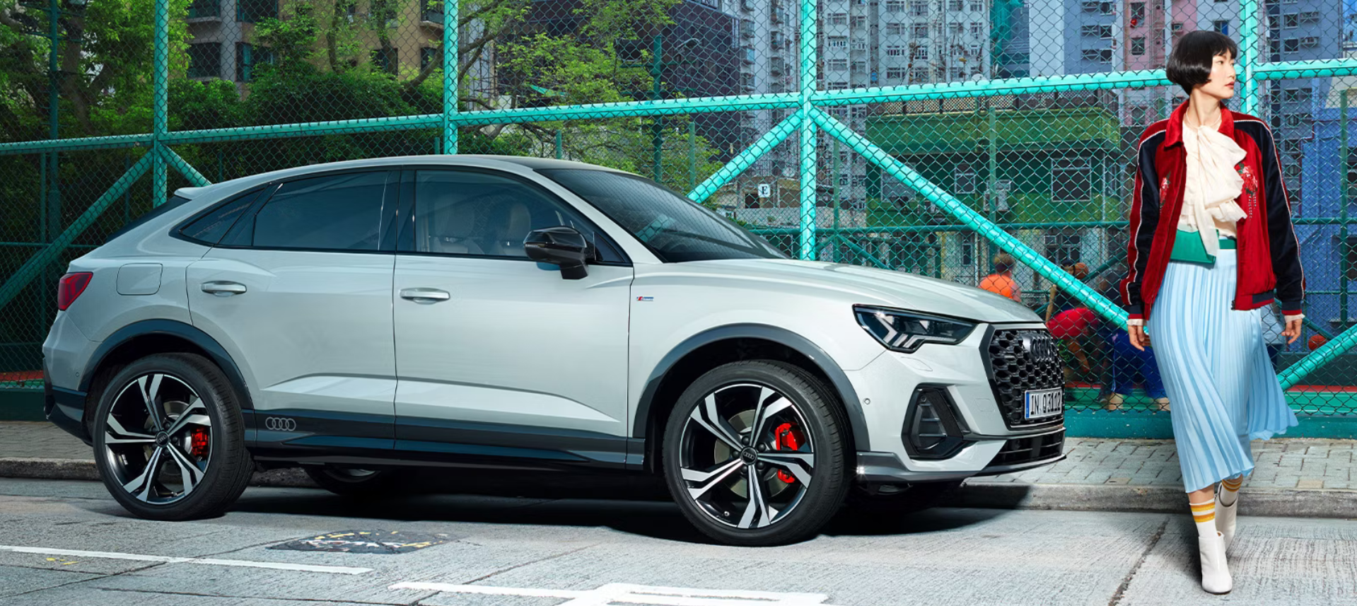 Seitenansicht Audi Q3 Sportback neben einem Model.