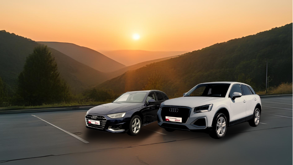 Zwei Audi Gebrauchtwagen auf einem Parkplatz bei Sonnenaufgang